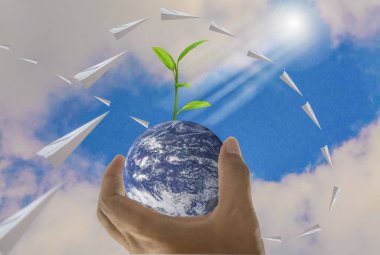 Dünya, bir avuç içinde kağıt uçak, orada parlak gökyüzü ile üst arka plan, insan kavramı doğal bir şifacı, Nasa tarafından döşenmiş bu görüntü unsurları olarak büyüyen ağaçlar vardır.