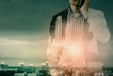 Konuşurken telefon, çevre düzenlemesi şehir arkasında, kavram vizyon başarı kurumsal liderler çift pozlama-işadamı duran.