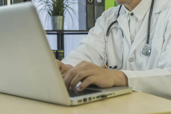 Medical professionals use  computer to research and analyze and record patient information, stethoscope