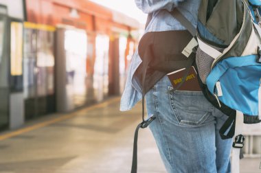 Bir trenin bir pasaport ile bekleyen bir backpacker görünümünü arka Jeans, eğlence, kavramı ile macera ve Seyahat planlayıcısı trenle, tek başına yaz tatilinde takılı.