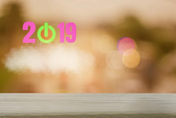 Happy new year with Wood table bokeh backgrounds sparkling, festival and holiday, abstract concept green button,  symbol of beginning of the year. 2019, montage has empty space and copy space to place