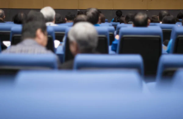 Rear view of audience attending meeting, listening to speaker on stage, online business seminar in conference room. Concept of Opening Digital Viewpoint