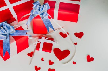 Sevgililer günü hediye kırmızı kutuları, kağıt kalp şeklinde, beyaz arka plan, kavram gün sevgi sembolize kutlayan festival üzerinde şerit ve mavi yayla kümesi.