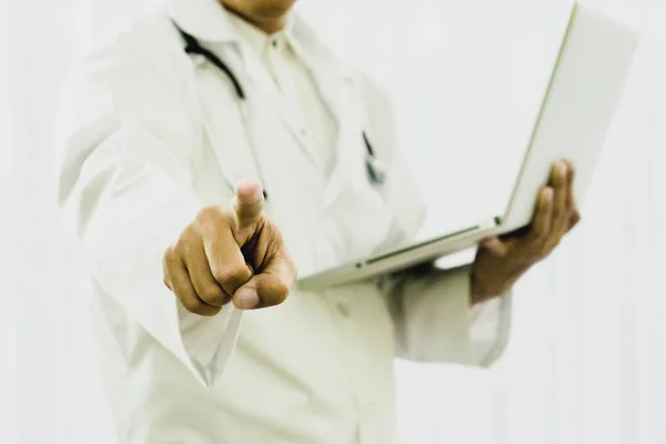 Doctor holds a laptop in hand And pointing in hospital, Analyze symptoms of patient to use as information in treatment of illness,Concepts of storage technology.