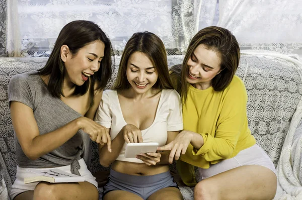 Beautiful female group three friends happy enjoy with tablet,soc
