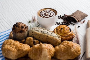 Beyaz fincan sıcak kahve ve güzel süslenmiş süt kabarcıkları, b