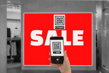 Kadınlar elinde akıllı telefon tutun, e- kupon için mağazanın Qr kodu tarayabilir 