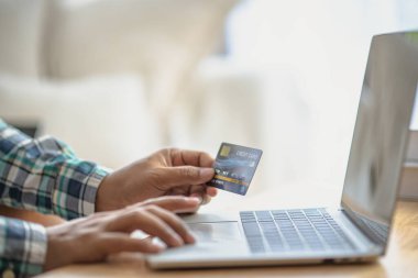 Bilgisayarlı alışveriş, ev ya da iş yerinde online ödeme, internet bankacılığı, ürün siparişi veren girişimciler veya harcamalar için gelecekteki yaşam tarzı fikirleri kullanarak kredi kartını kapatan adam elleri