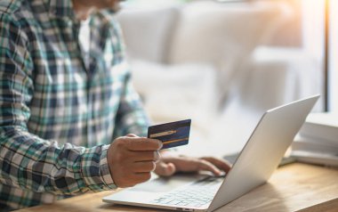 Bilgisayarlı alışveriş, ev ya da iş yerinde online ödeme, internet bankacılığı, ürün siparişi veren girişimciler veya harcamalar için gelecekteki yaşam tarzı fikirleri kullanarak kredi kartını kapatan adam elleri