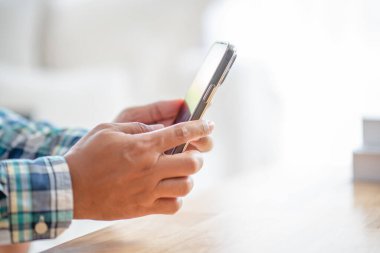 Serbest kariyer genç adam iş için telefon tutuyor başkentteki modern yaşam tarzıyla online görüşme yapıyor, dijital göçebe konsepti üzerinde çalışıyor.