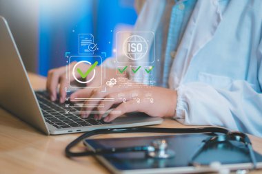 Sağlık hizmetlerine uyum, ISO sertifikası laptopta yapay zeka ile kontrol listesi olan profesyonel tıbbi tipler, steteskop, dijital kontrol işaretleri, belge onay iş akışı kalite güvencesi.