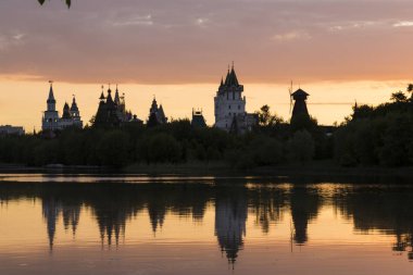 Izmailovsky Kremlin, Moskova, Rusya. Bir yaz akşamı gölün kıyısında inanılmaz inanılmaz çok renkli gün batımı. Muhteşem binalar suya yansıyor.