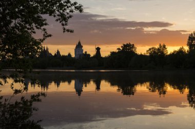 Izmailovsky Kremlin, Moskova, Rusya. Bir yaz akşamı gölün kıyısında inanılmaz inanılmaz çok renkli gün batımı. Muhteşem binalar suya yansıyor.