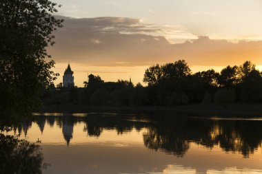 Bir yaz akşamı gölün kıyısında inanılmaz inanılmaz çok renkli gün batımı. Bulutlar suya yansıyor..