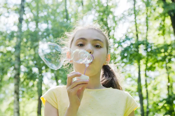 Tatlı küçük kız sabun köpüğü üflüyor..