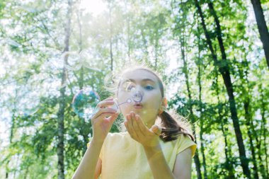 Tatlı küçük kız sabun köpüğü üflüyor..