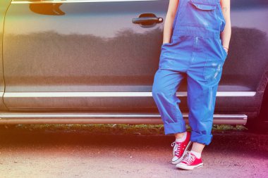 bir kadının arabasını yakınındaki bir çalışma üniforma ayakta.