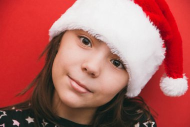 Santa Claus şapka kırmızı zemin üzerine, sevimli küçük kız.