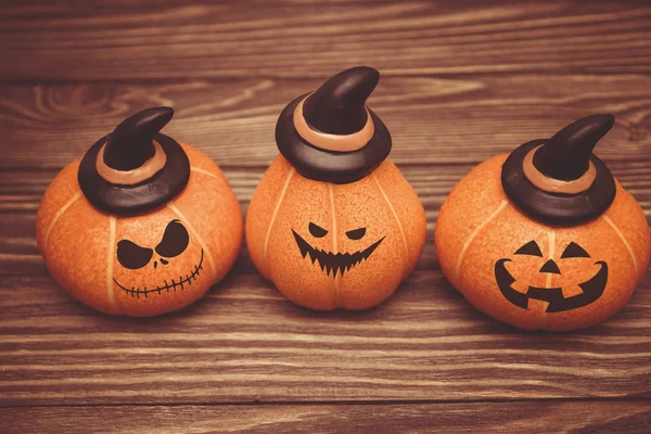 three laughing pumpkin faces frightening for Halloween on a wooden background. the symbol of Halloween.