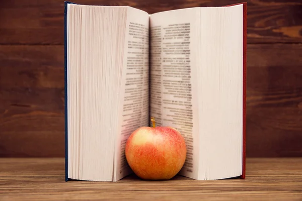 Чтение Книги Деревянном Фоне Красное Яблоко — стоковое фото