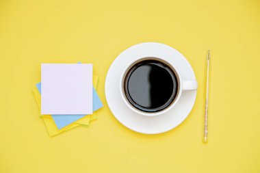 kalem ve çıkartmalar kahve Kupası kopya alanı üst sarı zemin üzerine görüntülemek.