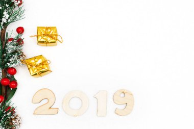 Altın hediye kutuları, dekoratif Ladin şube ve sembolü numaraları 2019 yeni yıl beyaz zemin üzerine, basit flatley Noel kartı. Seçici odak.