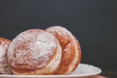 lezzetli donuts karanlık bir arka plan üzerinde doldurma ile pudra şekeri serpilir.