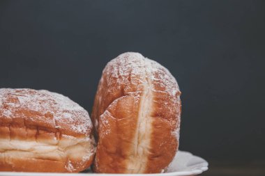lezzetli donuts karanlık bir arka plan üzerinde doldurma ile pudra şekeri serpilir.