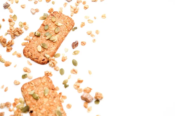 Galletas muesli rociadas con semillas de calabaza, aisladas sobre un fondo blanco, enfoque selectivo. Vista superior, espacio de copia — Foto de Stock