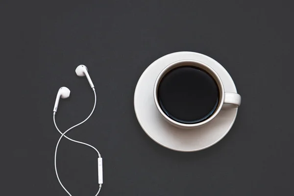 Headphones and a Cup of coffee on a black background. Musical concept. Top view with copy space — Stock Photo, Image