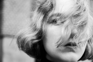 Saçları rüzgarda dalgalanan genç sarışın kız yakın plan portresi