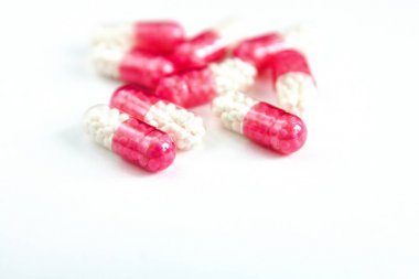 pembe Kapsüller beyaz arka plan üzerinde izole, metin için boşaltmak, seçici odak, üst görünüm. Ağrı ilaçlar, sağlık, bağımlılık kavramı tedavisi için haplar