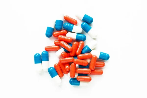 Multicolored capsules isolated on white background, copyspace for text, selective focus, top view. Pain meds, health, pills for the treatment of the concept of drug abuse