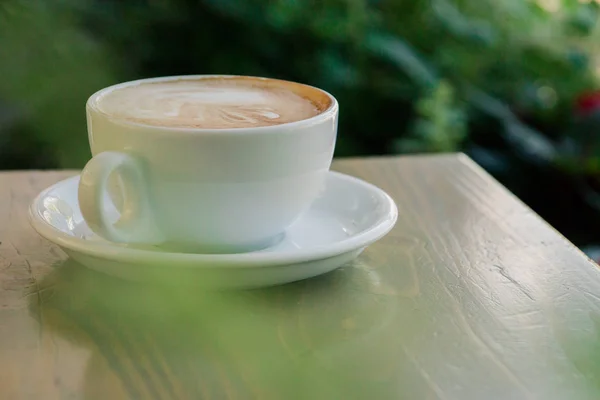 Kopp färskt cappuccino på bordet på sommarcaféet — Stockfoto