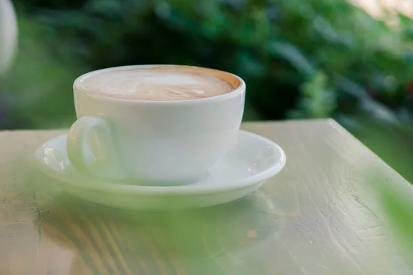 Kopp färskt cappuccino på bordet på sommarcaféet — Stockfoto