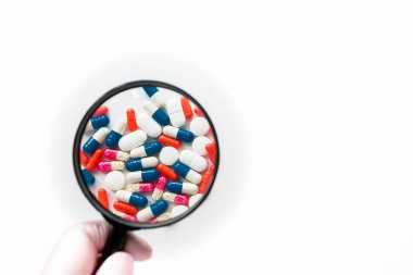 Beyaz arka planda yalıtılmış çok renkli kapsüller, metin için boşaltmak, seçici odak, üst görünüm. İlaç istismarı kavramının tedavisi için ağrı ilaçları, sağlık, haplar