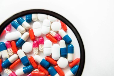 Beyaz arka planda yalıtılmış çok renkli kapsüller, metin için boşaltmak, seçici odak, üst görünüm. İlaç istismarı kavramının tedavisi için ağrı ilaçları, sağlık, haplar