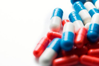 Beyaz arka planda yalıtılmış çok renkli kapsüller, metin için boşaltmak, seçici odak, üst görünüm. İlaç istismarı kavramının tedavisi için ağrı ilaçları, sağlık, haplar