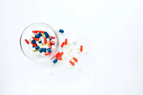 Capsule multicolori isolate su sfondo bianco, copyspace per testo, messa a fuoco selettiva, vista dall'alto. Antidolorifici, salute, pillole per il trattamento del concetto di abuso di droga — Foto Stock