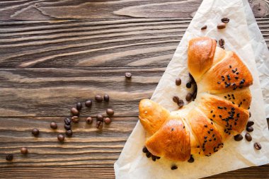 dokulu ahşap arka plan üst görünümünde kruvasan ve kahve çekirdekleri, rahat ve lezzetli Kahvaltı. Kopya alanı ile rustik arka plan