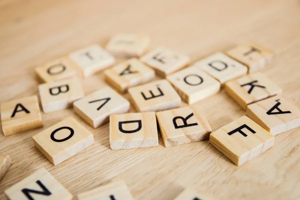 Montón de letras de madera en la superficie de un fondo de madera, enfoque selectivo —  Fotos de Stock