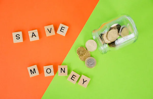 the future of Finance, business banking and financial concept. Flatlay Euro cents, glass jar and cubic letters save money on two color background