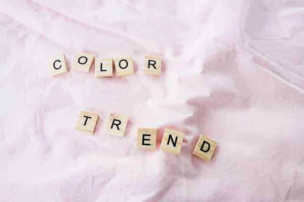 De tekstkleur trend is geschreven in kubieke letters op een roze kleur textiel achtergrond, selectieve focus — Stockfoto