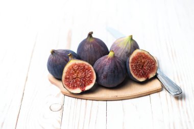 Beyaz ahşap bir masa üzerinde taze olgun incir. Sağlıklı Akdeniz inciri. Güzel mavi mor incir, seçici odak