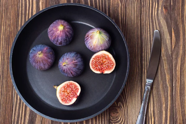 Fresh ripe figs in a dark pan on a wooden table. Healthy Mediterranean figs, selective focus — Stock Photo, Image