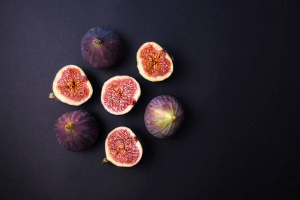 Fresh ripe figs on a dark table. Healthy Mediterranean figs. Fresh figs on black background. Beautiful blue purple Fig, selective focus — Stock Photo, Image