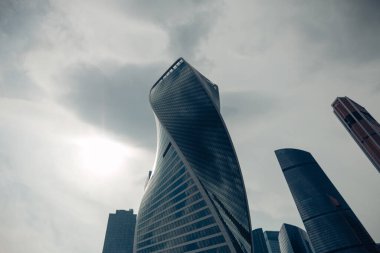 Moskova şehrinin yüksek modern cam kulesi bulutlu karanlık gökyüzüne karşı iş geçmişi için. Moskova, Rusya, Haziran 2020.