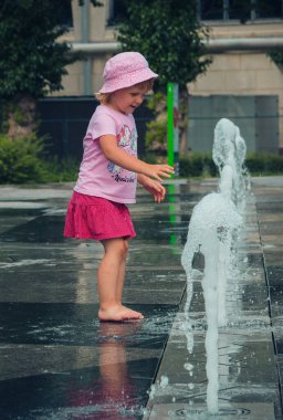 Sıcak yaz havası, parktaki çeşmede yıkanan bilinmeyen küçük çocuklar. Moskova, Rusya, Temmuz 2020.