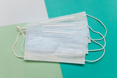 Üç farklı renkte tıbbi geçmişi olan üç beyaz tıbbi maske. Seçici odak.