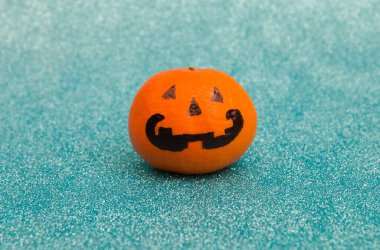 Parlak turuncu Cadılar Bayramı Korkunç Mandarin duyguları mavi parlak arka planda, seçici odaklanma.